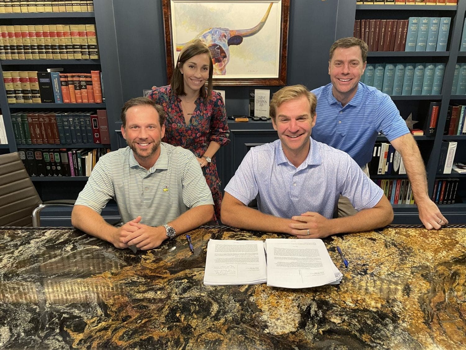 Four members of the Cannon Field team at a closing table, signing the documents that complete a transaction.